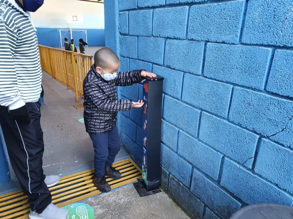 Aulas presenciais em Nova Lima- menino passando álcool