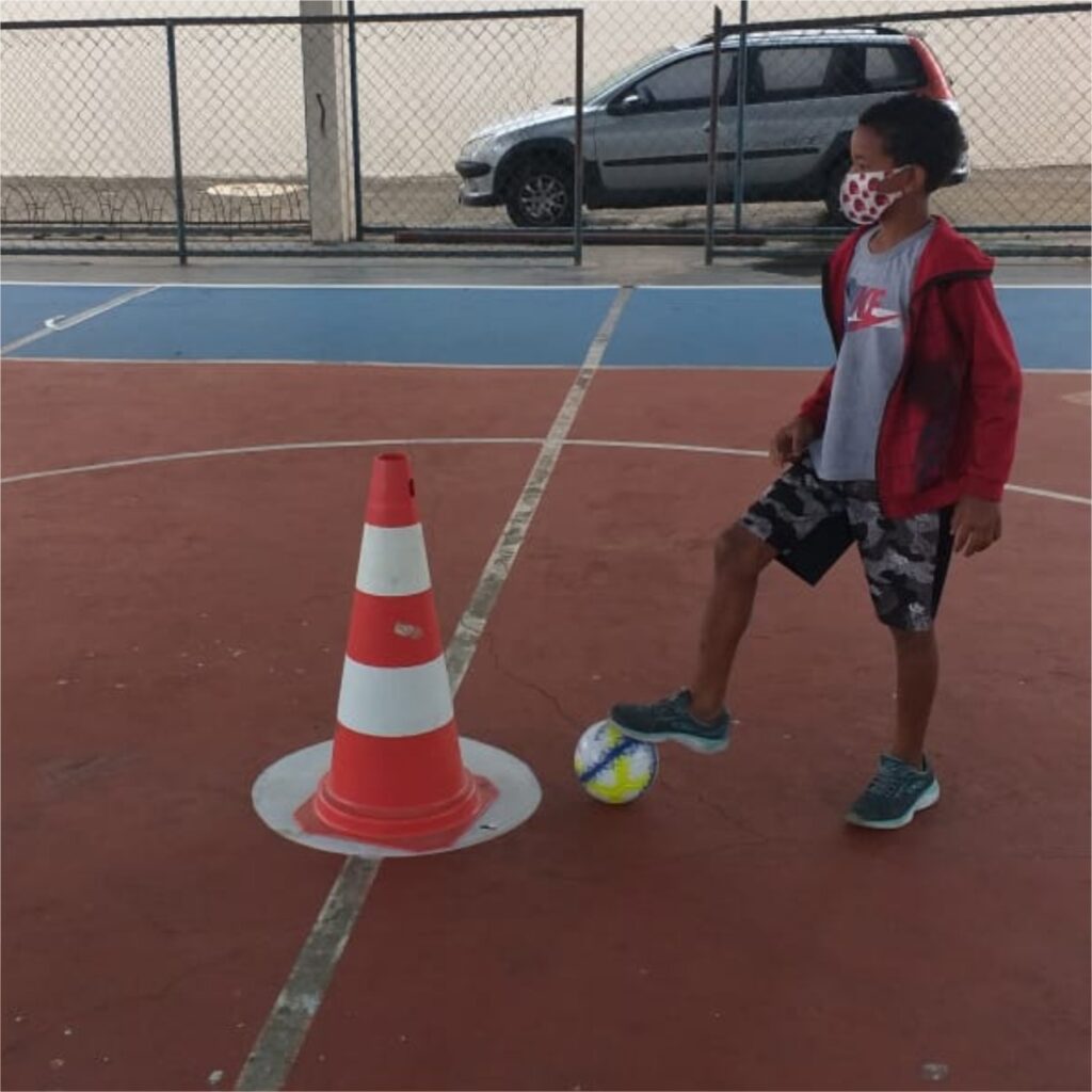 Instituto Mais Ação - Retorno das aulas presenciais em Itaguaí - Beneficiado com bola no pé em frente ao cone