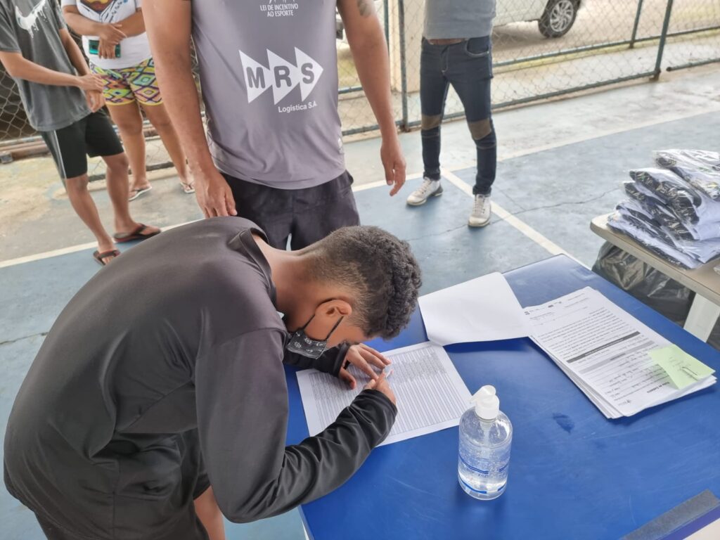 Instituto Mais Ação - Projeto em Itaguaí entrega uniforme - Beneficiado assinando nome