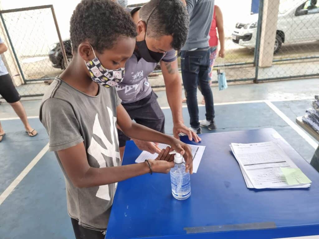 Instituto Mais Ação - Projeto em Itaguaí entrega uniforme - Beneficiado higienizando as mãos