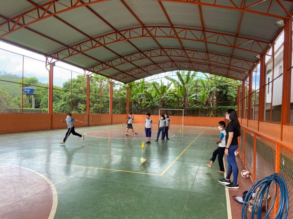 Instituto Mais Ação - Aulas em Santa Bárbara - Beneficiados chutando a bola em atividade com cone