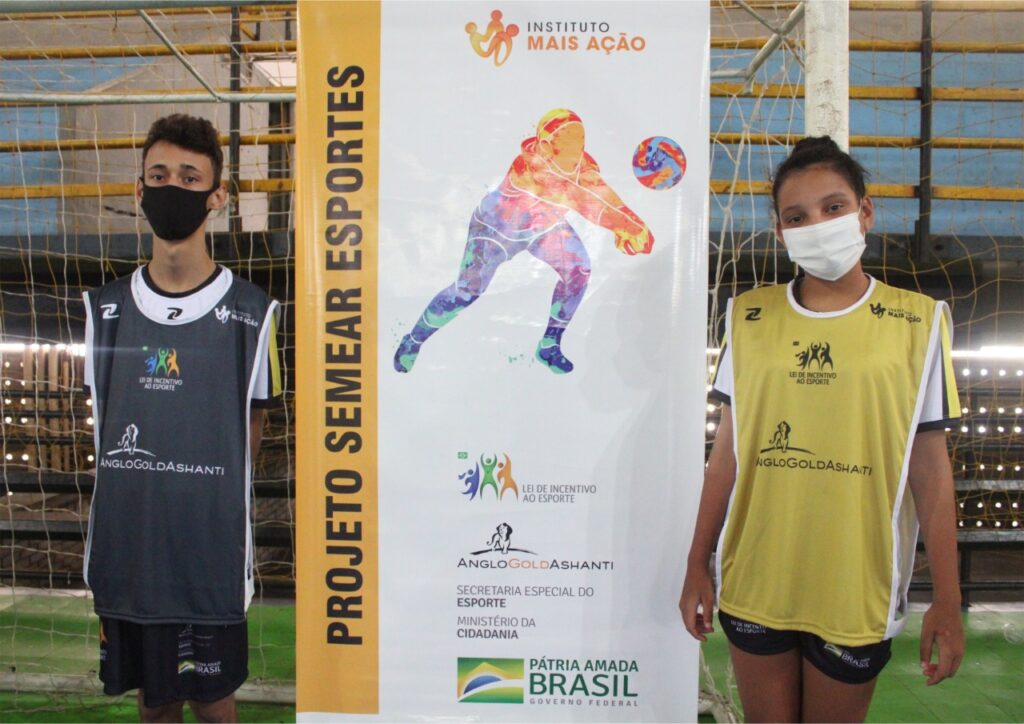Instituto Mais Ação - Caeté recebe uniforme de aula - beneficiados ao lado do banner