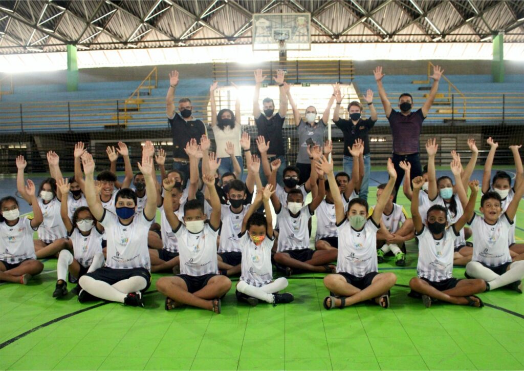 Instituto Mais Ação - Caeté recebe uniforme de aula - beneficiados com as mãos para cima com uniforme